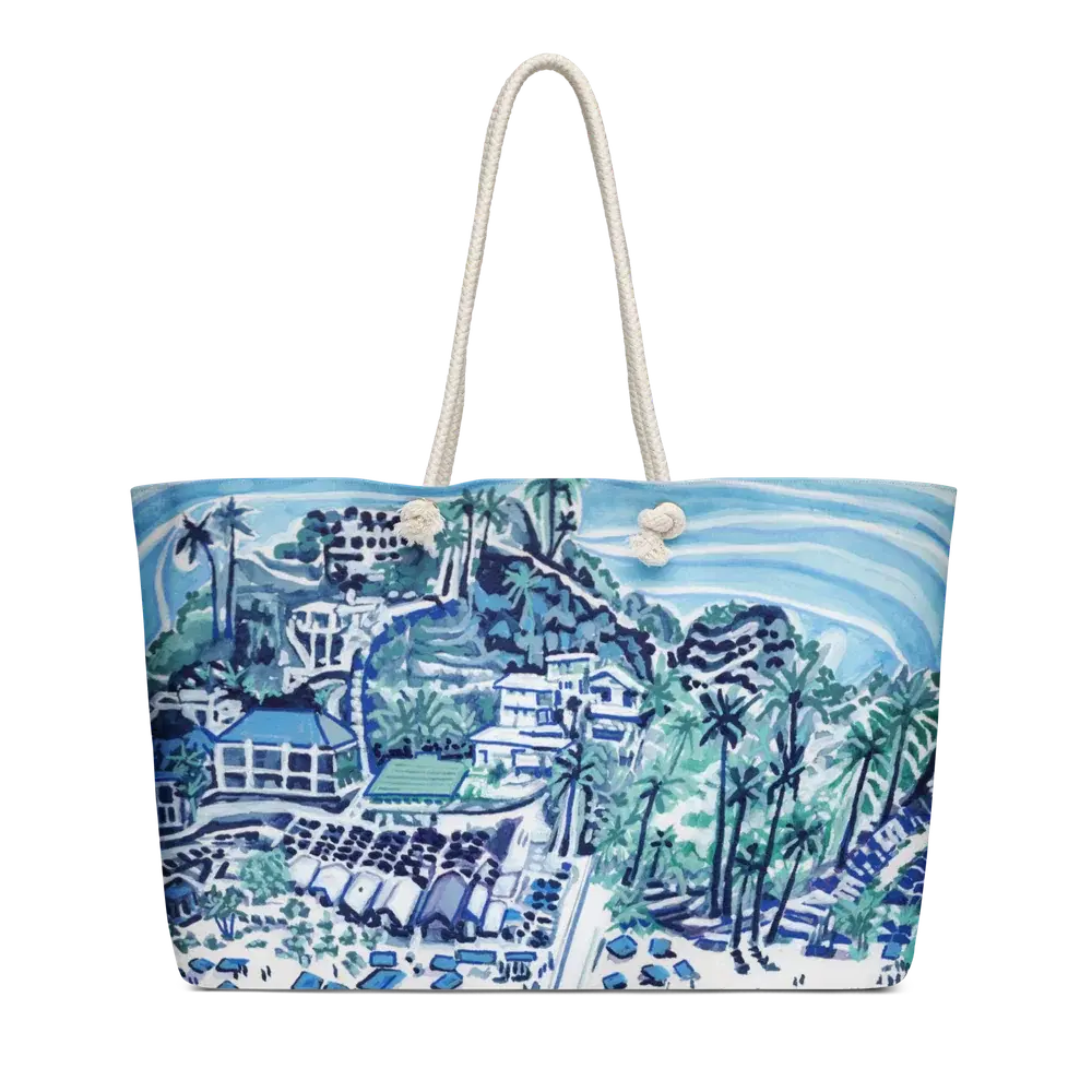 Beach tote with rope handles, printed with a blue and teal painting of houses and palm trees on a hillside above the beach